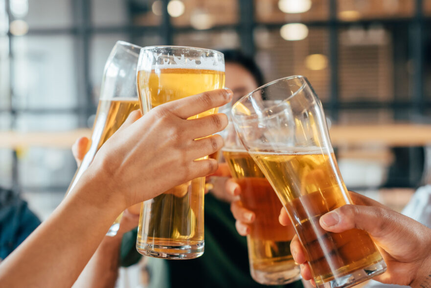 Friends clinking with beer in cafe -Depositphotos
